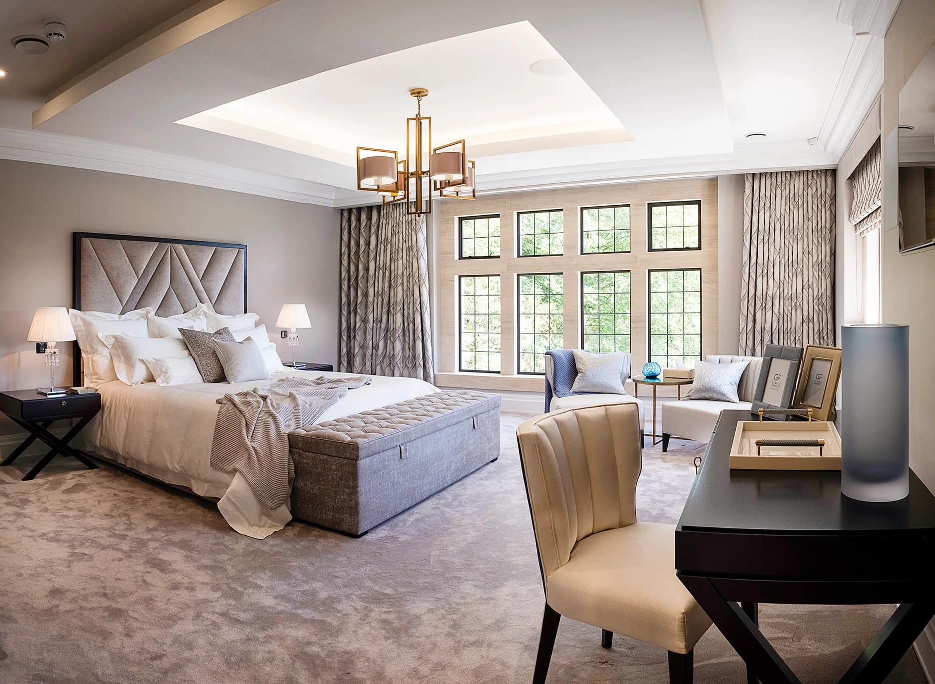 A beautifully made bed with luxurious white and gold linens.